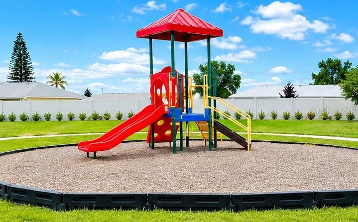 A colorful playground structure with a red slide sits on a wood-chipped surface outdoors — 333 MARION LOOP, HAINES CITY, FL