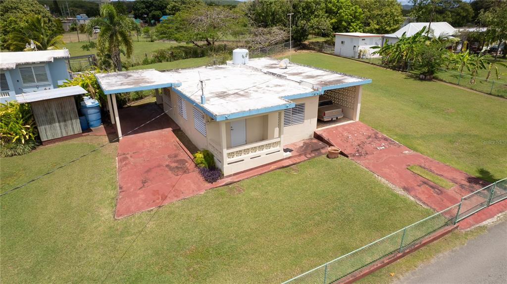 An aerial view shows a single-story house with a flat roof, carport, and red driveway — 195 CALLE ALMENDRO, VIEQUES, PR