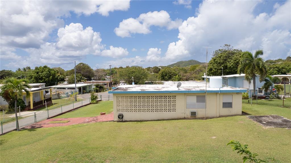A view of the backyard and exterior of a single-story house with a flat roof — 195 CALLE ALMENDRO, VIEQUES, PR