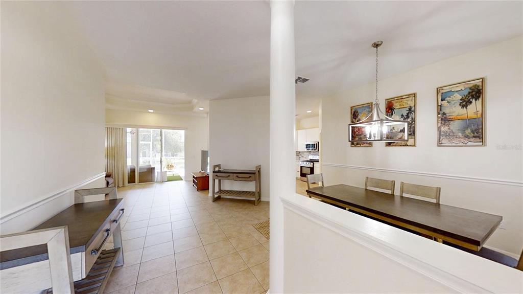 A dining area with a wooden table and chairs sits adjacent to a tiled living space — 8328 SW 84TH PLACE ROAD, OCALA, FL