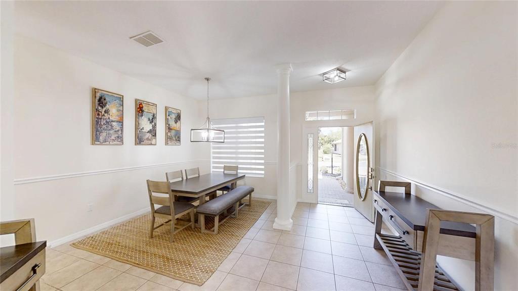 A dining room with a table, bench, chairs, and an entryway with a front door — 8328 SW 84TH PLACE ROAD, OCALA, FL