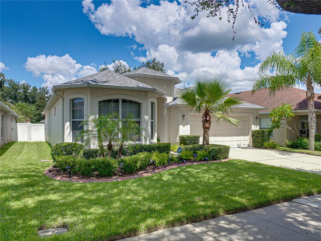 A single-story house with a beige stucco exterior, a two-car garage, and a landscaped yard — 2530 CROSS MORE STREET, VALRICO, FL