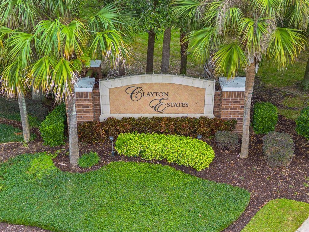 A brick and stone monument sign for Clayton Estates stands surrounded by palm trees — 629 MARY PAULA DRIVE, APOPKA, FL