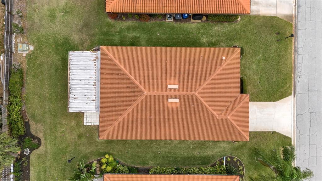 An aerial view shows a house with a terracotta tile roof and a white patio — 3215 MERCER ROAD, BRADENTON, FL