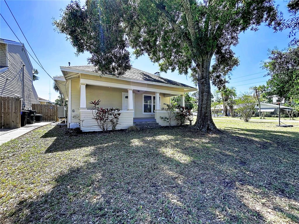 A yellow single-story house with a front porch and large tree in the yard — 313 JEFFERSON AVENUE S, OLDSMAR, FL