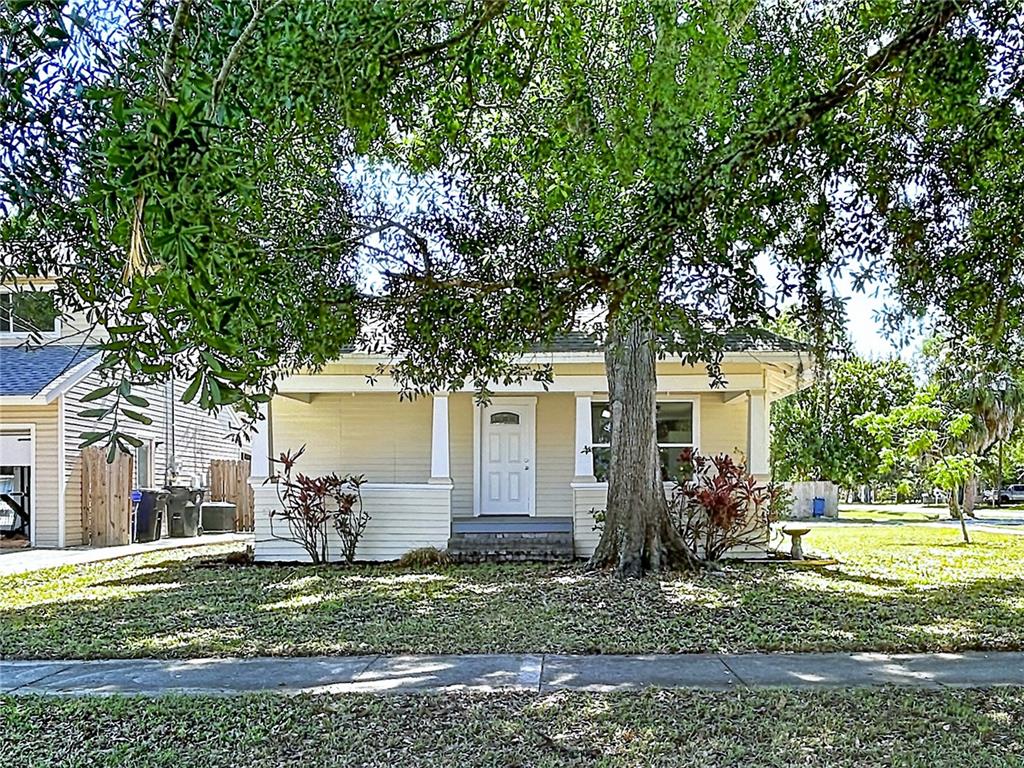 A single-story yellow house with a front porch sits behind a large tree — 313 JEFFERSON AVENUE S, OLDSMAR, FL