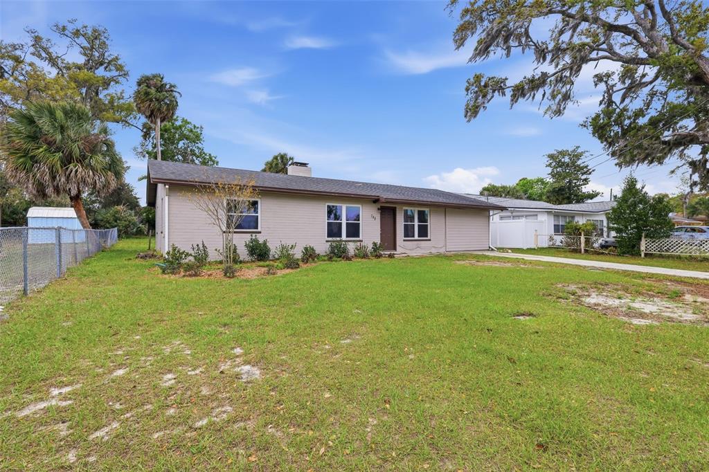 A single-story house with light-colored siding and a brown roof sits on a grassy lot — 748 COLFAX DRIVE, DAYTONA BEACH, FL