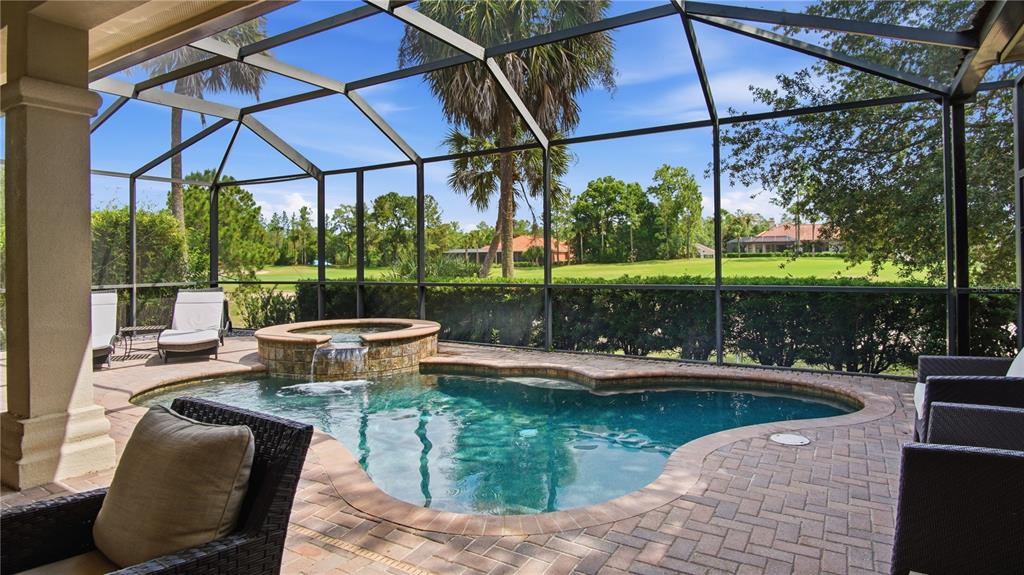 A screened-in patio features a small pool with an attached hot tub and brick pavers — 6609 SW 179TH AVENUE ROAD, DUNNELLON, FL