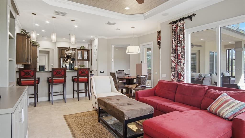 A living room with a red sectional sofa, a kitchen bar, and sliding glass doors — 6609 SW 179TH AVENUE ROAD, DUNNELLON, FL