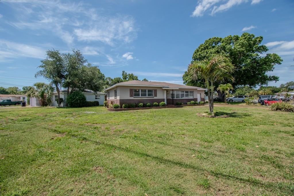 A single-story house with a tan exterior and a large, grassy front yard — 5800 21ST AVENUE S, GULFPORT, FL