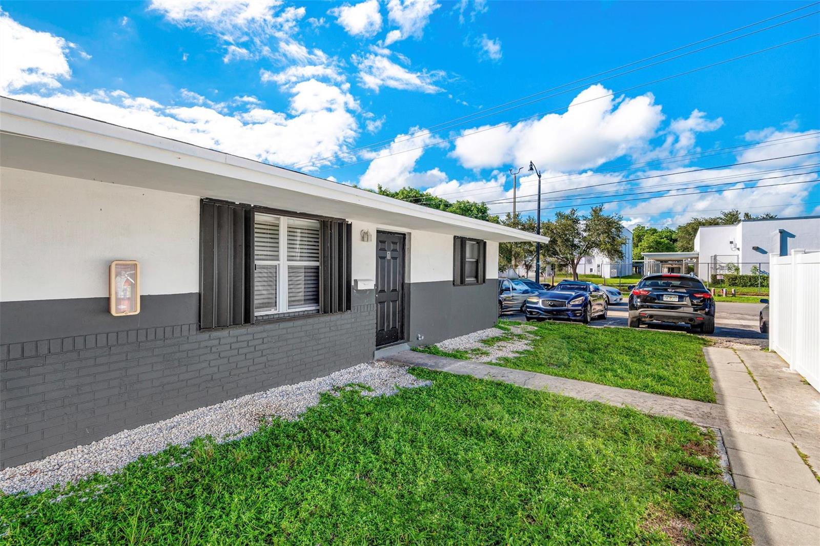 A single-story building with a gray and white exterior, a black door, and a lawn — 404 NE 4th Street, Pompano Beach FL 33060, POMPANO BEACH, FL