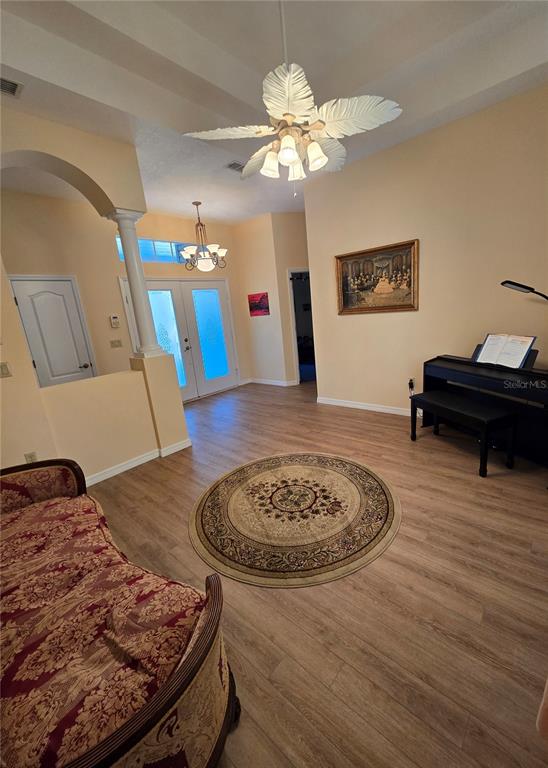 A living room features light wood flooring, a ceiling fan, and a piano — 25344 CROOM ROAD, BROOKSVILLE, FL