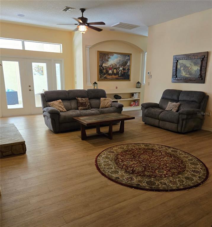 A living room features two gray sofas, a coffee table, and a circular area rug — 25344 CROOM ROAD, BROOKSVILLE, FL
