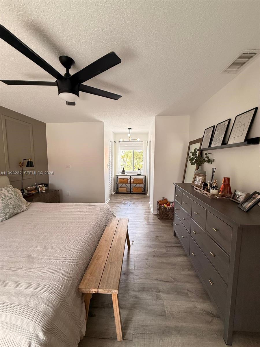 A bedroom features a wooden bench, a large gray dresser, and a ceiling fan — 1054 SE 6th Ct, Dania Beach FL 33004, DANIA BEACH, FL