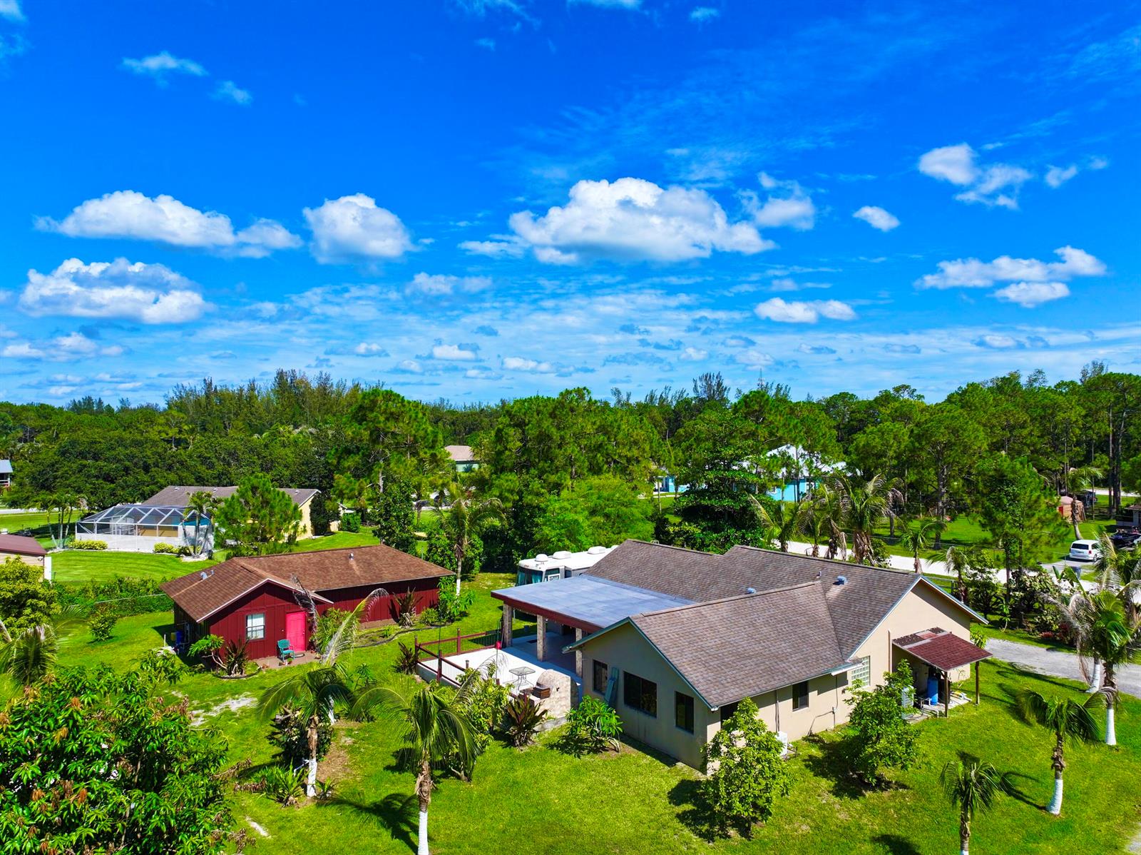 An aerial view shows two houses with brown roofs surrounded by trees and green lawns — 14539 N 60th Ct Court N, FL 33470, FL
