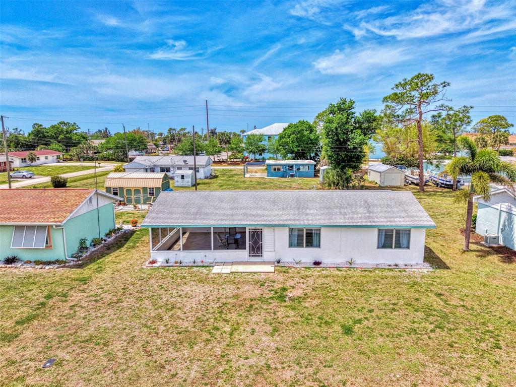 An aerial view shows a white single-story house with a screened porch and large yard — 2870 9TH STREET, ENGLEWOOD, FL