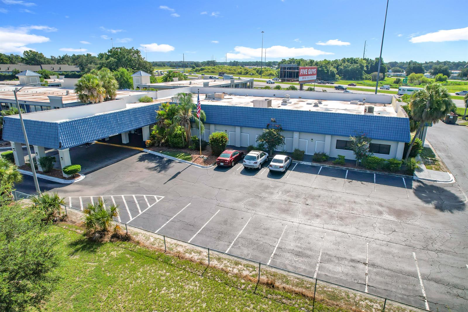 An aerial view shows a commercial building with a blue roof and a parking lot — 4645 N Socrum Loop Road # 101, Lakeland FL 33809, LAKELAND, FL