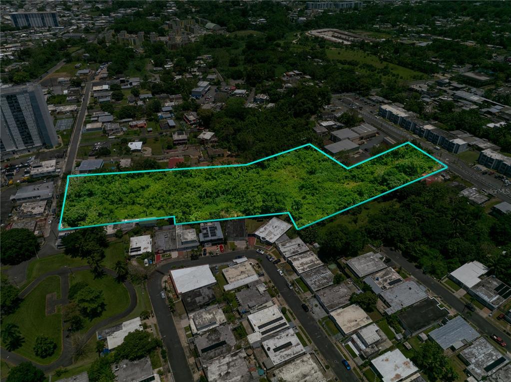 An aerial view shows a vacant, vegetated lot outlined in blue within a residential area — CLL RAMON FIGUEROA CASTRO SAN ANTON, CAROLINA, PR