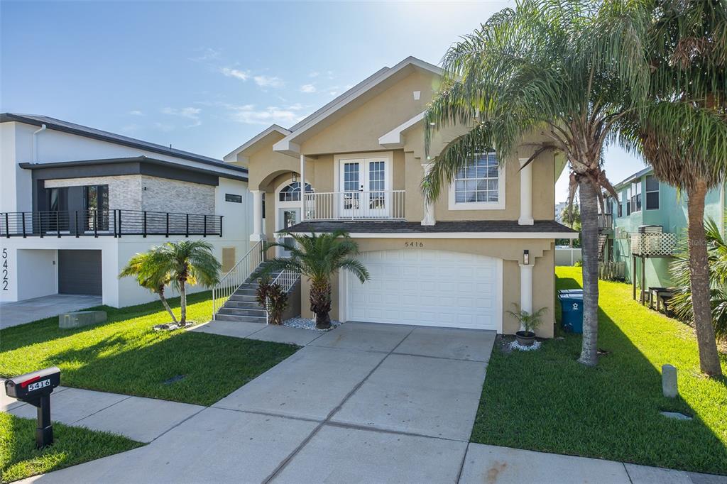 A two-story house with a beige stucco exterior, a white garage door, and a front balcony — 5416 JOBETH DRIVE, NEW PORT RICHEY, FL