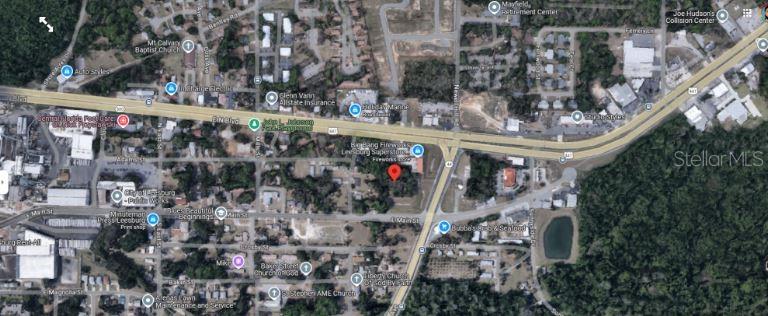 This is an aerial map view showing a property location marked with a red pin — 1216 E MAIN STREET, LEESBURG, FL