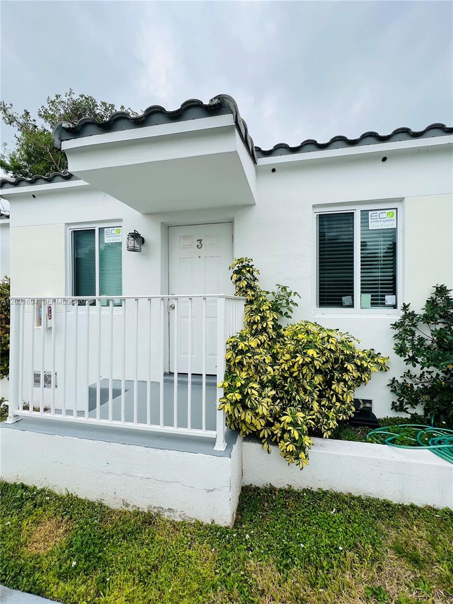 The exterior of a white building features a small porch, a numbered door, and windows — 850 81st St # 3, Miami Beach FL 33141, MIAMI BEACH, FL