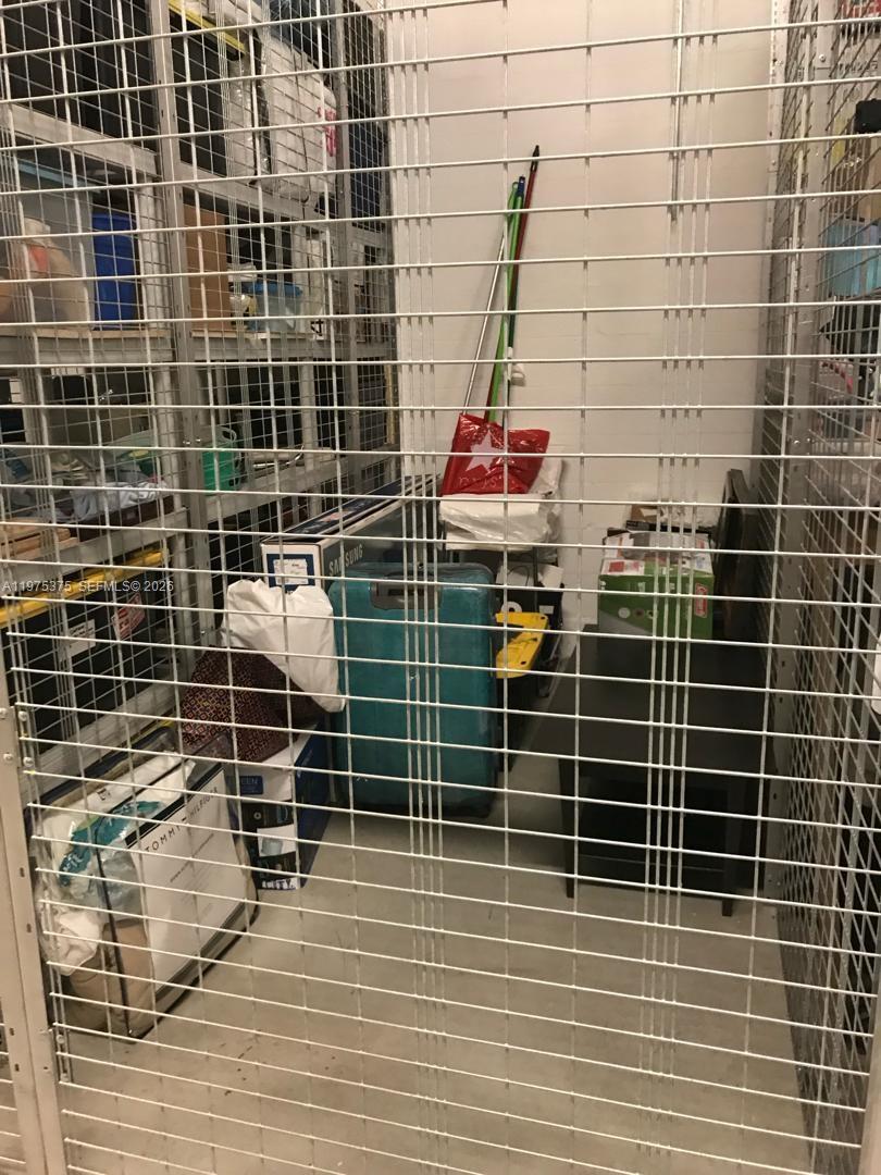 A storage unit with wire mesh walls contains boxes, a suitcase, and cleaning supplies — 5252 NW 85th Ave # 1203, Doral FL 33166, DORAL, FL