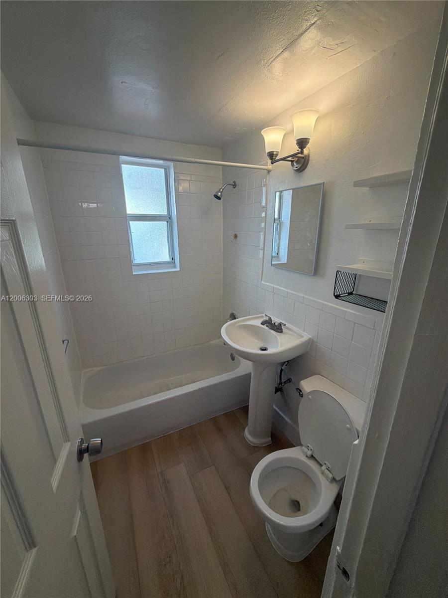 A small bathroom features a pedestal sink, a toilet, and a tub-shower combination — 3669 Thomas Ave # 9, Miami FL 33133, MIAMI, FL