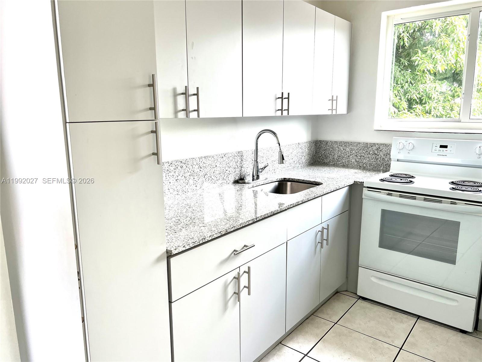 A kitchen features white cabinets, granite countertops, a stainless steel sink, and a white stove — 2121 SW 4th St # 2, Miami FL 33135, MIAMI, FL