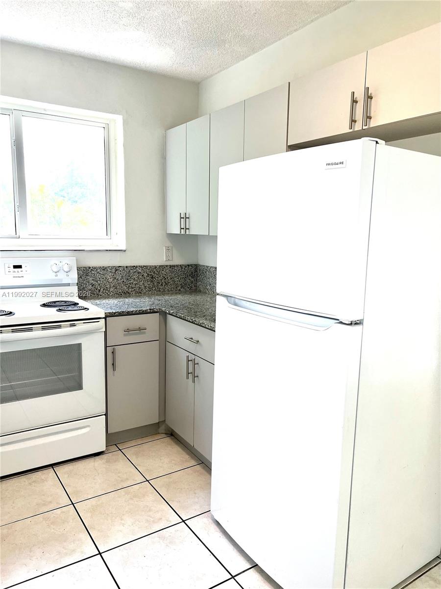 A kitchen features white cabinets, granite countertops, a white stove, and a white refrigerator — 2121 SW 4th St # 2, Miami FL 33135, MIAMI, FL