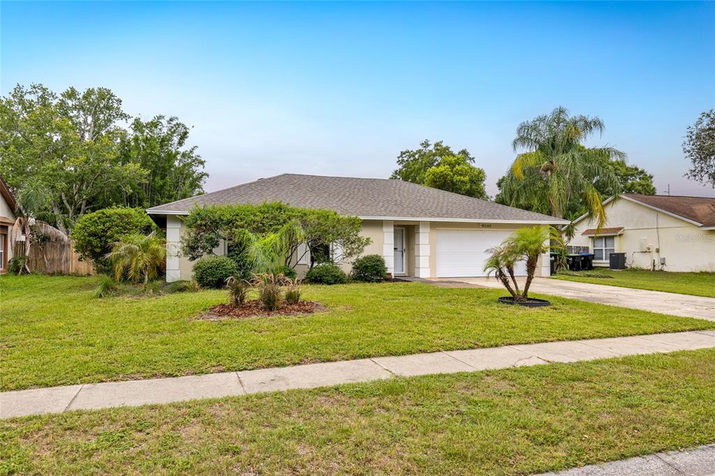 A single-story house with a beige exterior, a two-car garage, and a front lawn — 8040 CLOVERGLEN CIRCLE, ORLANDO, FL