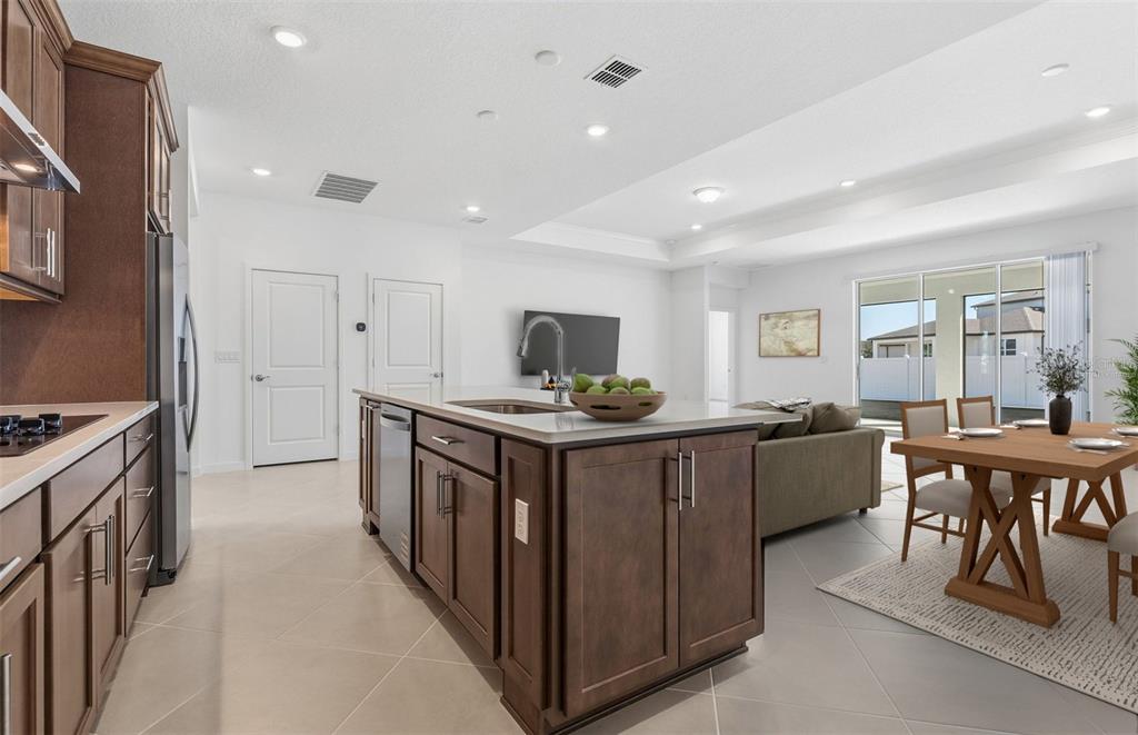 A kitchen with dark wood cabinets, a central island, and an adjacent dining area — 6736 SW 89TH LANE, OCALA, FL