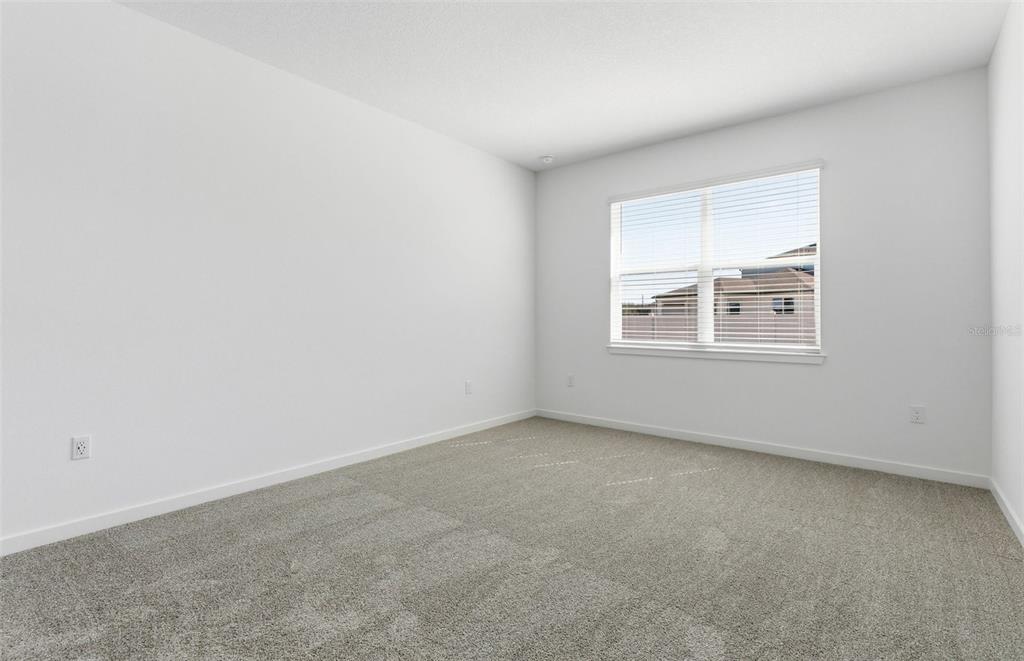 An empty bedroom features white walls, gray carpet, and a window with white blinds — 6736 SW 89TH LANE, OCALA, FL