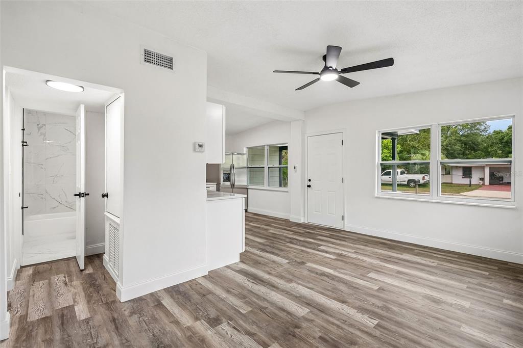 A kitchen with white cabinets, stainless steel appliances, and wood-look flooring in an open room — 806 CITRUS STREET, ORLANDO, FL