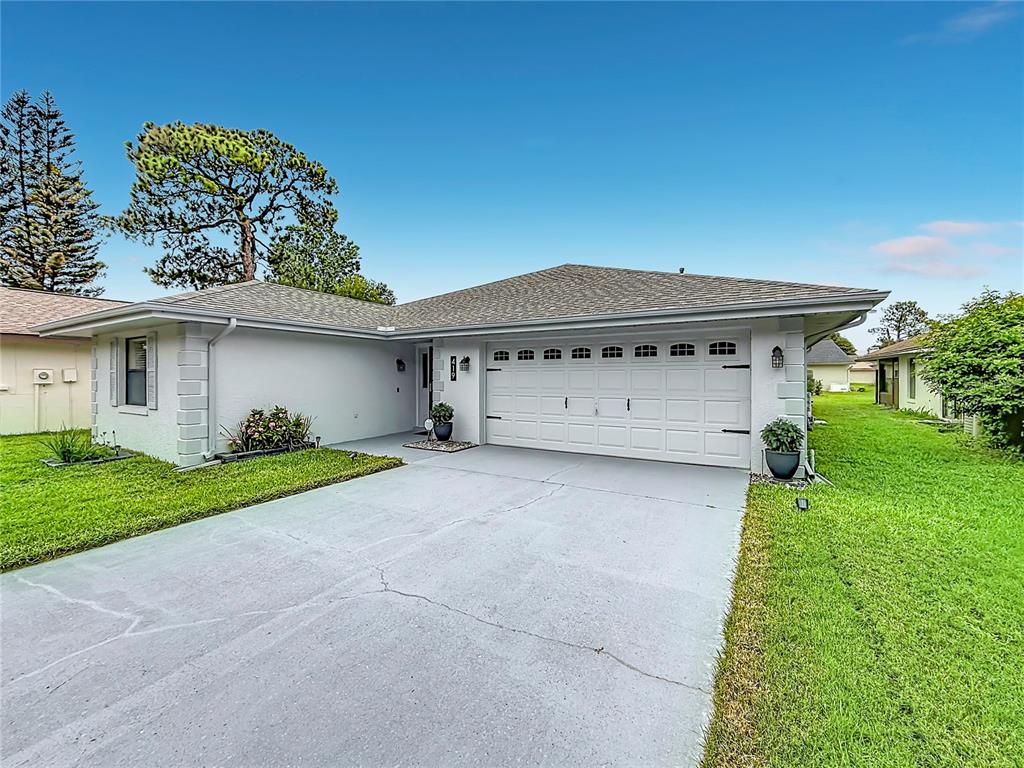 A single-story house with a white exterior, a two-car garage, and a concrete driveway — 419 GREENFIELD ROAD, WINTER HAVEN, FL