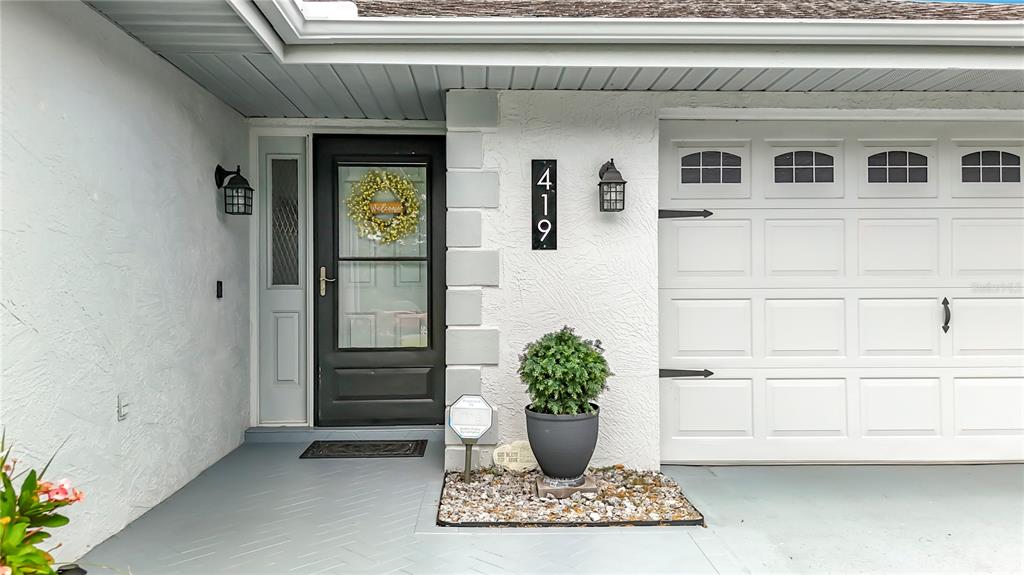 The exterior view shows a front door, a garage, and a potted plant — 419 GREENFIELD ROAD, WINTER HAVEN, FL