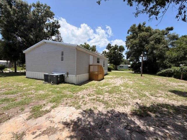 A light gray mobile home sits on a grassy lot with a wooden deck — 4301 SHERWICK DRIVE, TAMPA, FL