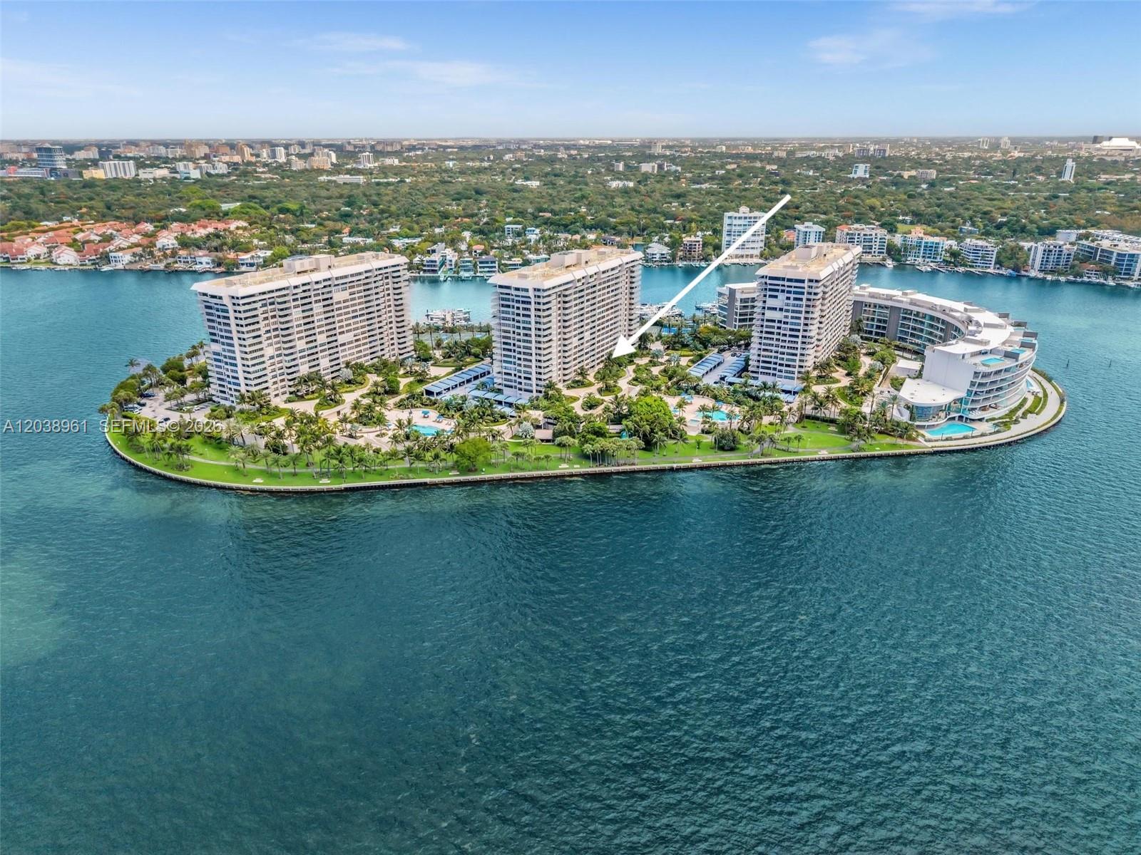 An aerial view shows several high-rise residential buildings situated on a landscaped island — 2 Grove Isle Dr # B205, Miami FL 33133, MIAMI, FL