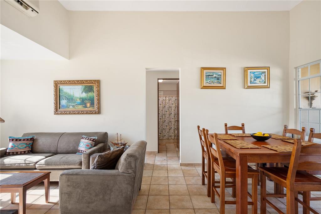 A living and dining area with tile floors, a brown sofa, and a wooden table — 1 COSTA DORADA UNIT B303, RIO GRANDE, PR