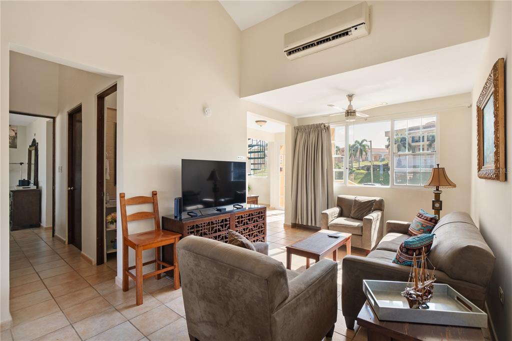 A living room with tile floors, a vaulted ceiling, a ceiling fan, and a television console — 1 COSTA DORADA UNIT B303, RIO GRANDE, PR