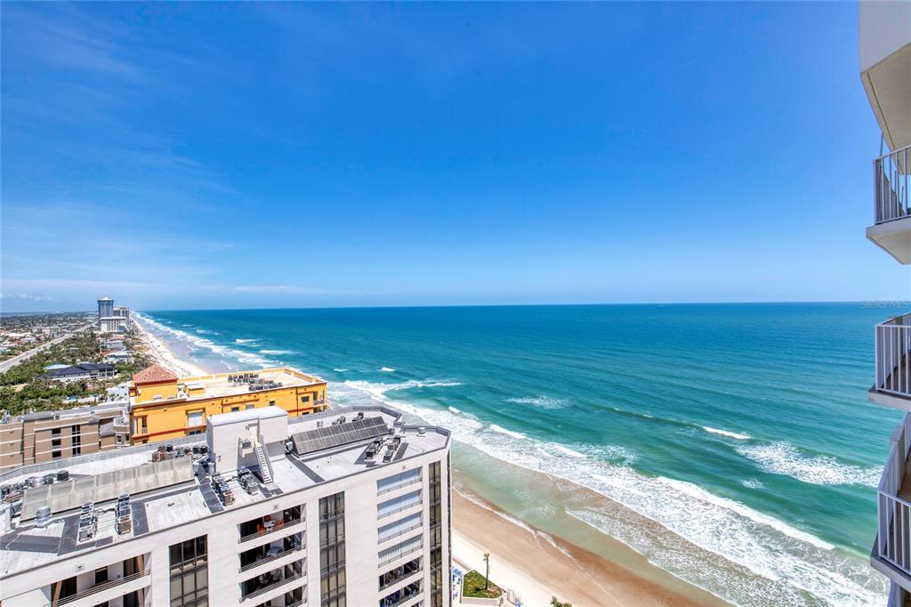 An elevated view of a sandy beach and ocean from a high-rise balcony — 2937 S ATLANTIC AVENUE UNIT 2001, DAYTONA BEACH, FL