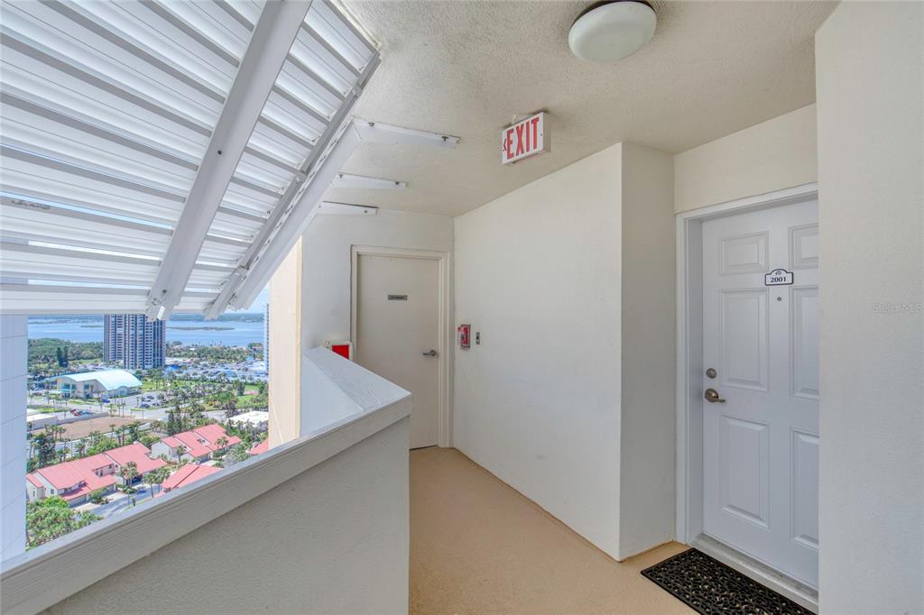 An outdoor apartment hallway features a white door labeled 2001 and a view of water — 2937 S ATLANTIC AVENUE UNIT 2001, DAYTONA BEACH, FL