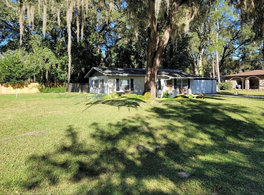 A single-story house with a large front yard and a prominent tree in the center — 4808 NE 3RD PLACE, GAINESVILLE, FL