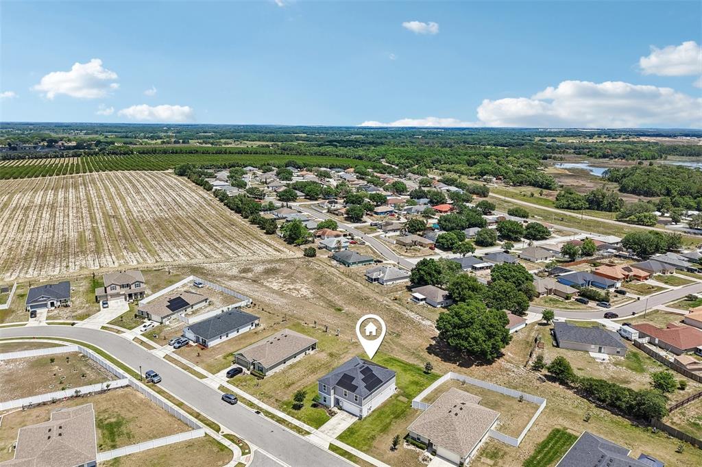 An aerial view shows a suburban house with solar panels on its roof — 2082 FICUS STREET, MASCOTTE, FL