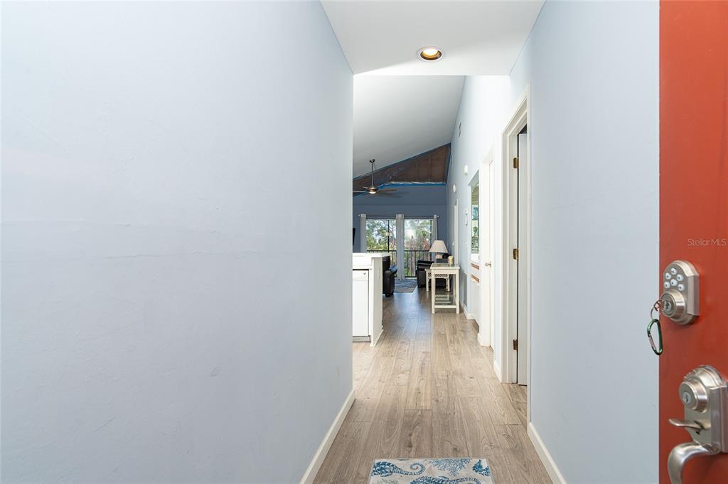 A view from an entryway looking into a living area with light wood-look flooring — 6800 PLACIDA ROAD UNIT 262, ENGLEWOOD, FL