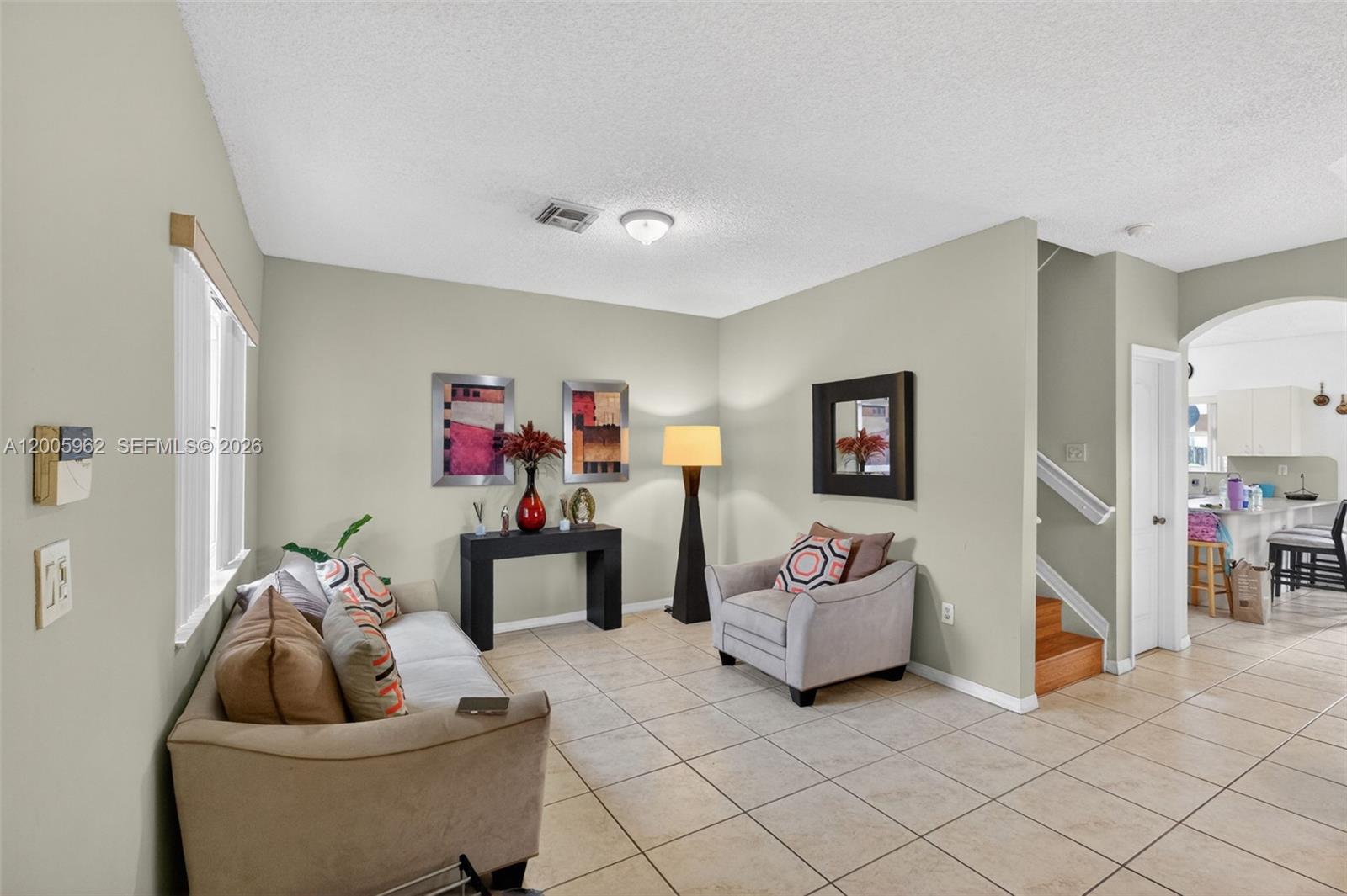A living room features beige tile floors, light green walls, a sofa, and an armchair — 16624 NW 73rd Ct # 16624, Miami Lakes FL 33014, MIAMI LAKES, FL