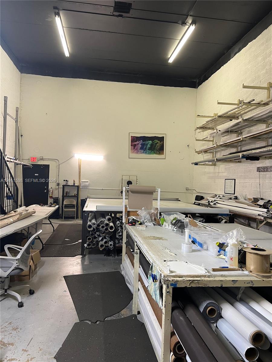This industrial workspace features high ceilings, fluorescent lighting, and multiple large work tables with storage — 13210 SW 132nd Ave, Miami FL 33186, MIAMI, FL