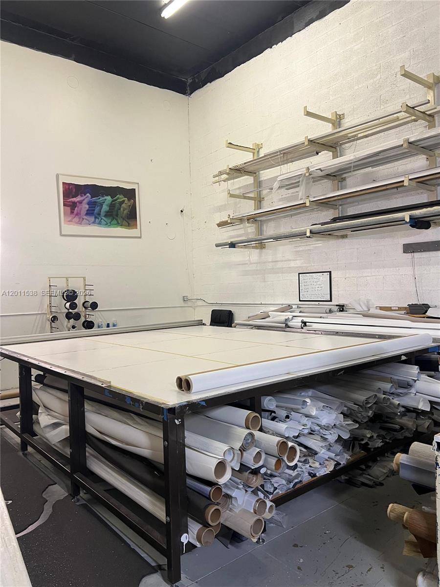 A workshop space features a large central work table surrounded by rolls of material — 13210 SW 132nd Ave, Miami FL 33186, MIAMI, FL