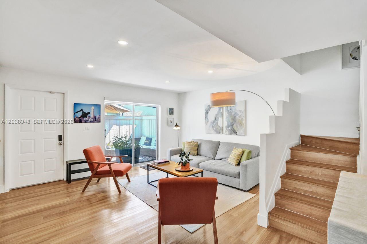 A living room features light wood floors, a gray sofa, two orange chairs, and stairs — 4555 SW 68th Ct Cir # 111, Miami FL 33155, MIAMI, FL