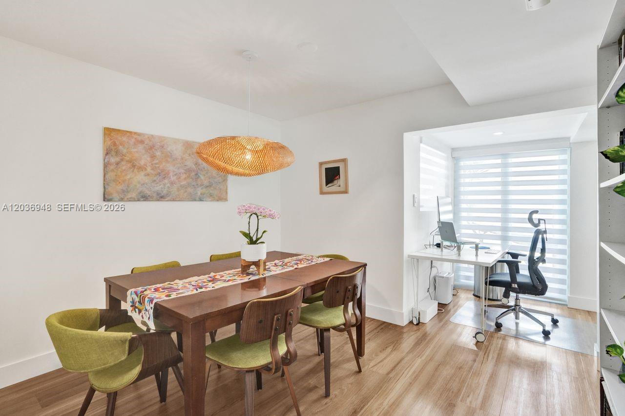 A dining area with a wooden table and chairs sits adjacent to a home office — 4555 SW 68th Ct Cir # 111, Miami FL 33155, MIAMI, FL