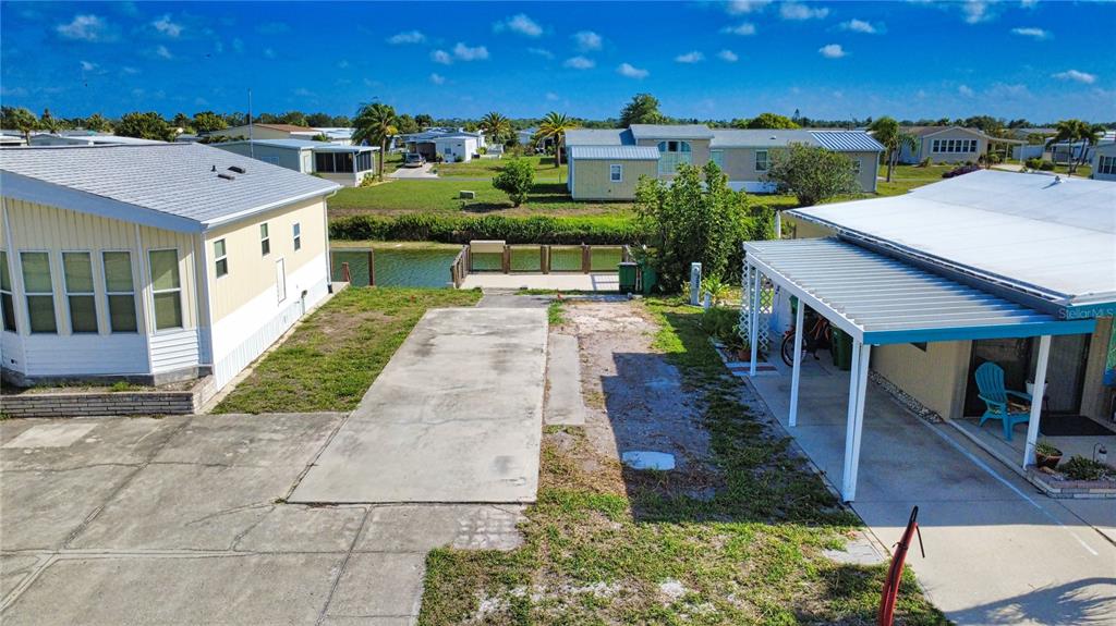An aerial view shows two mobile homes separated by a concrete driveway and a canal — 1475 FLAMINGO DRIVE UNIT 389, ENGLEWOOD, FL